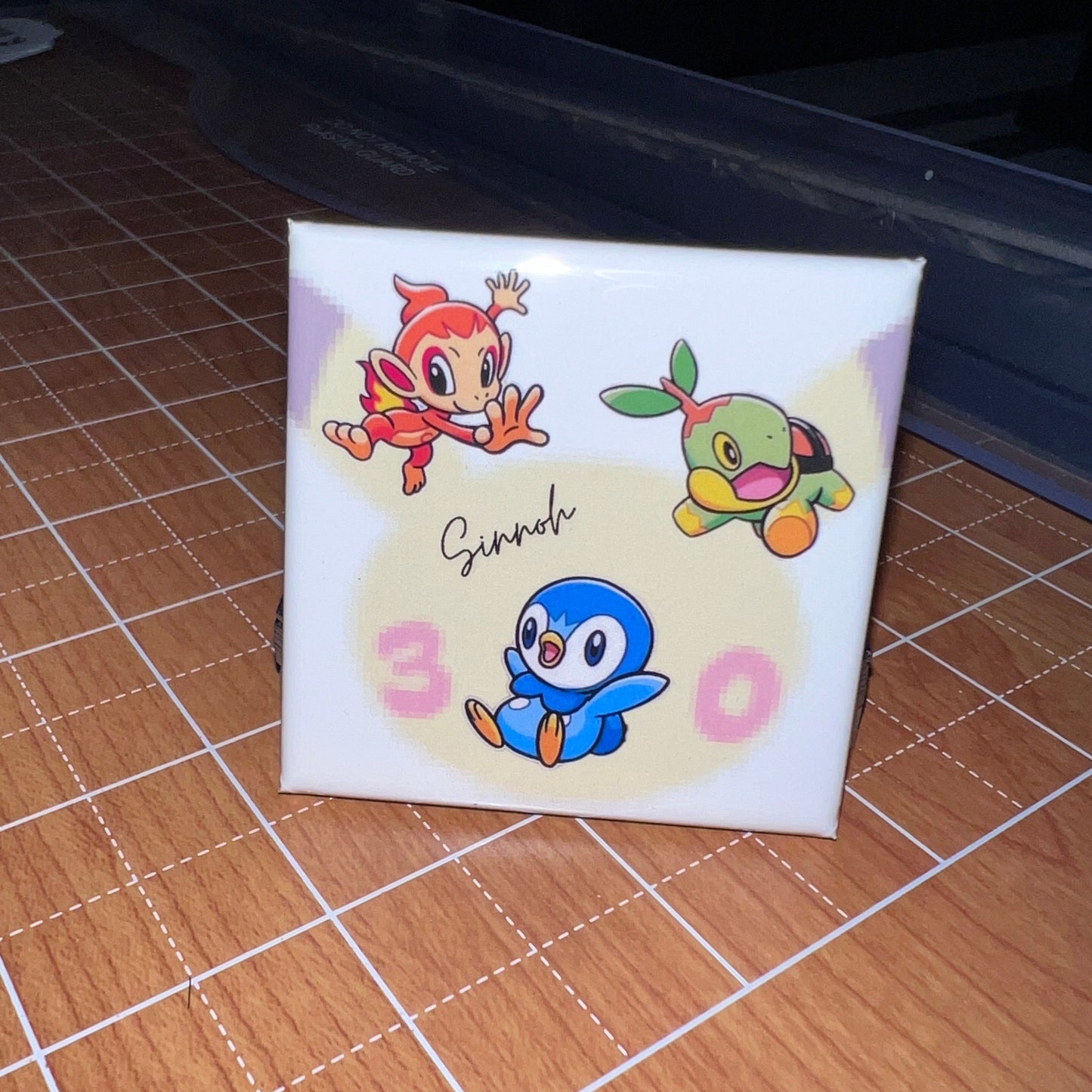 Small square card with cartoon characters on a wooden surface