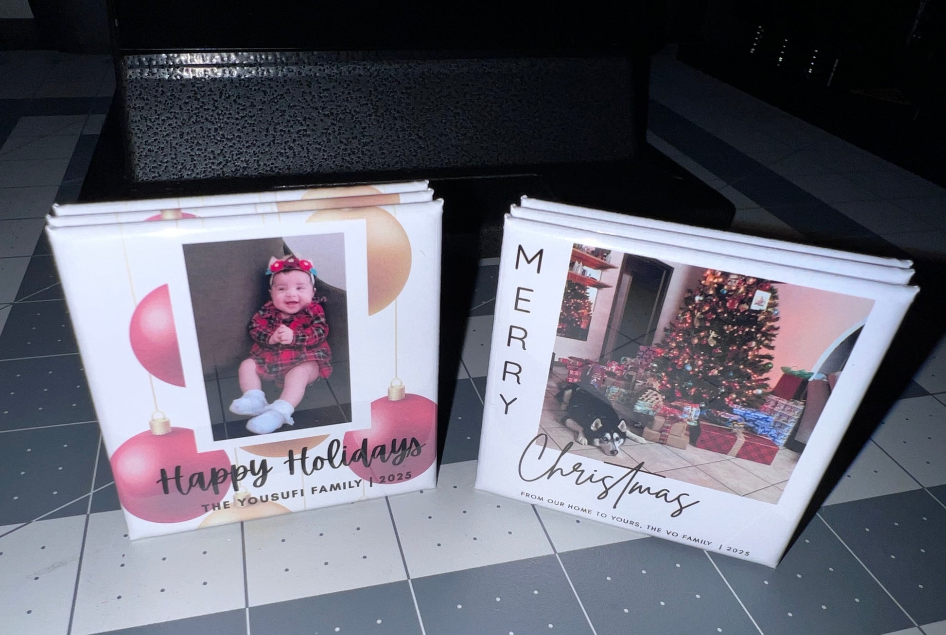 Two Christmas-themed photo magnets on a dark surface
