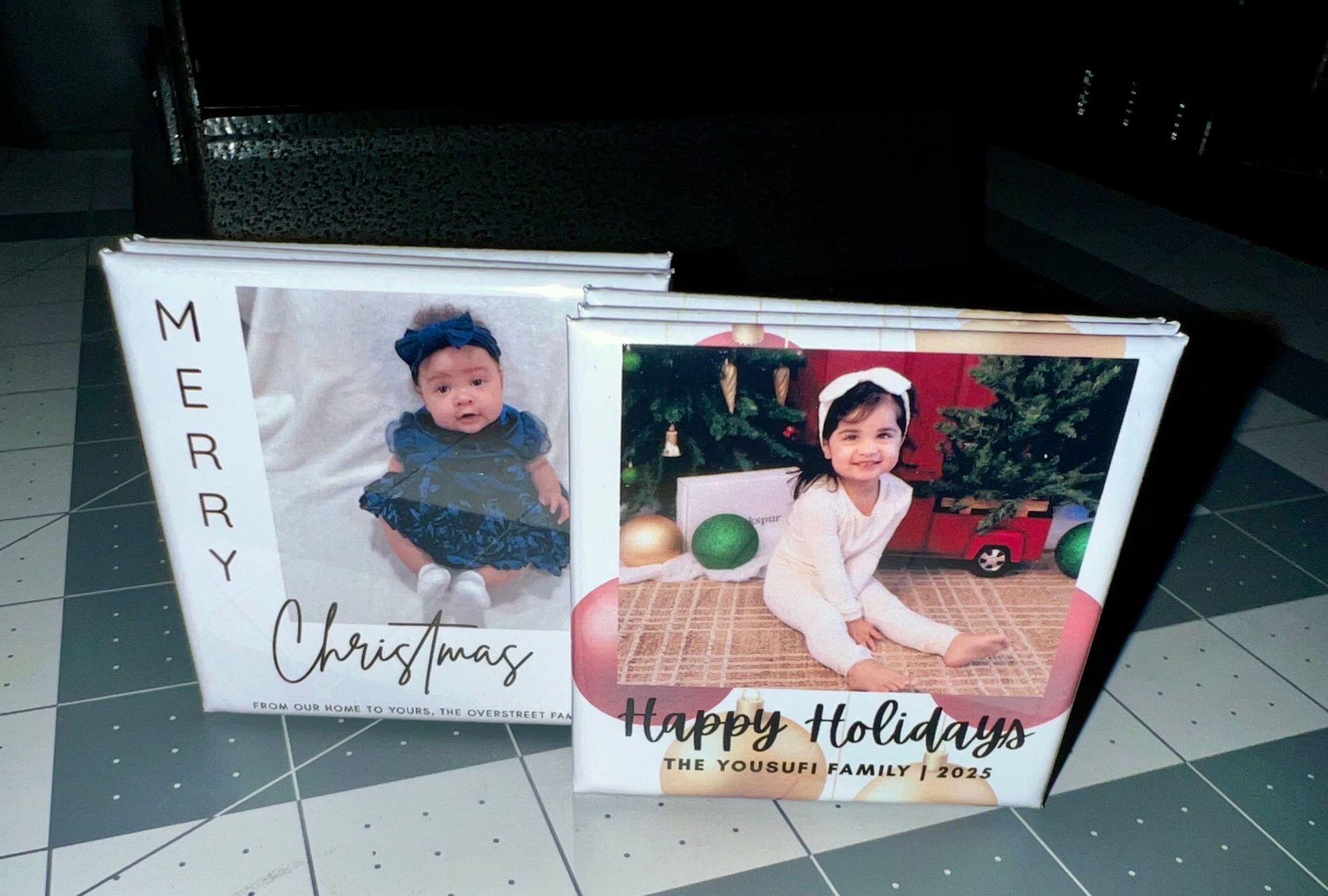 Two photo magnets with Christmas-themed covers featuring children and festive scenes.